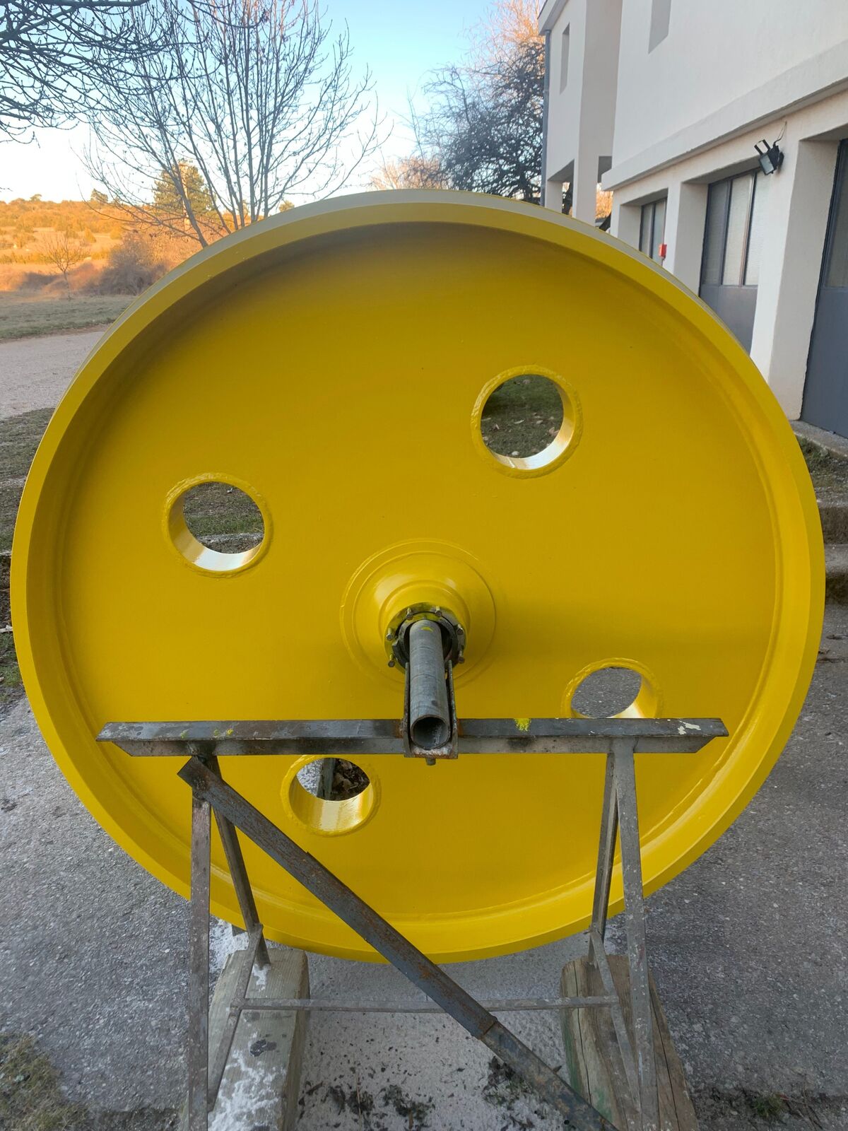 La poulie industrielle remise en peinture jaune après préparation de surface par sablage